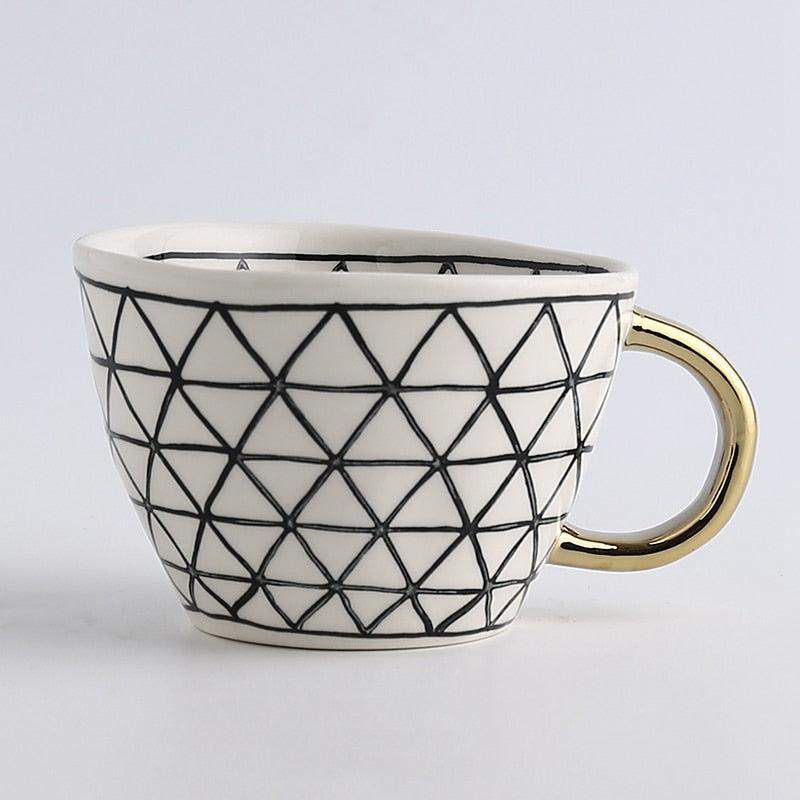 Kop med abstrakt geometrisk mønster og guldhåndtag