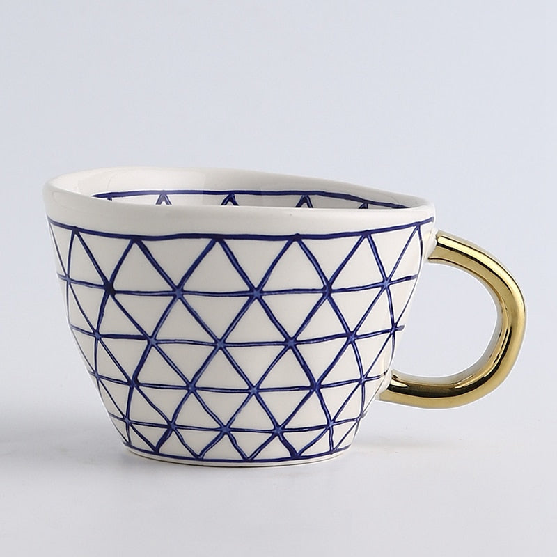 Kop med abstrakt geometrisk mønster og guldhåndtag