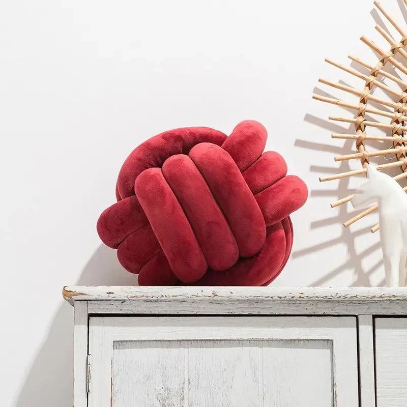 Dekorativ, blød pude med knyttet bold i suede look