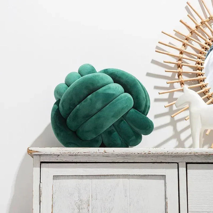 Dekorativ, blød pude med knyttet bold i suede look